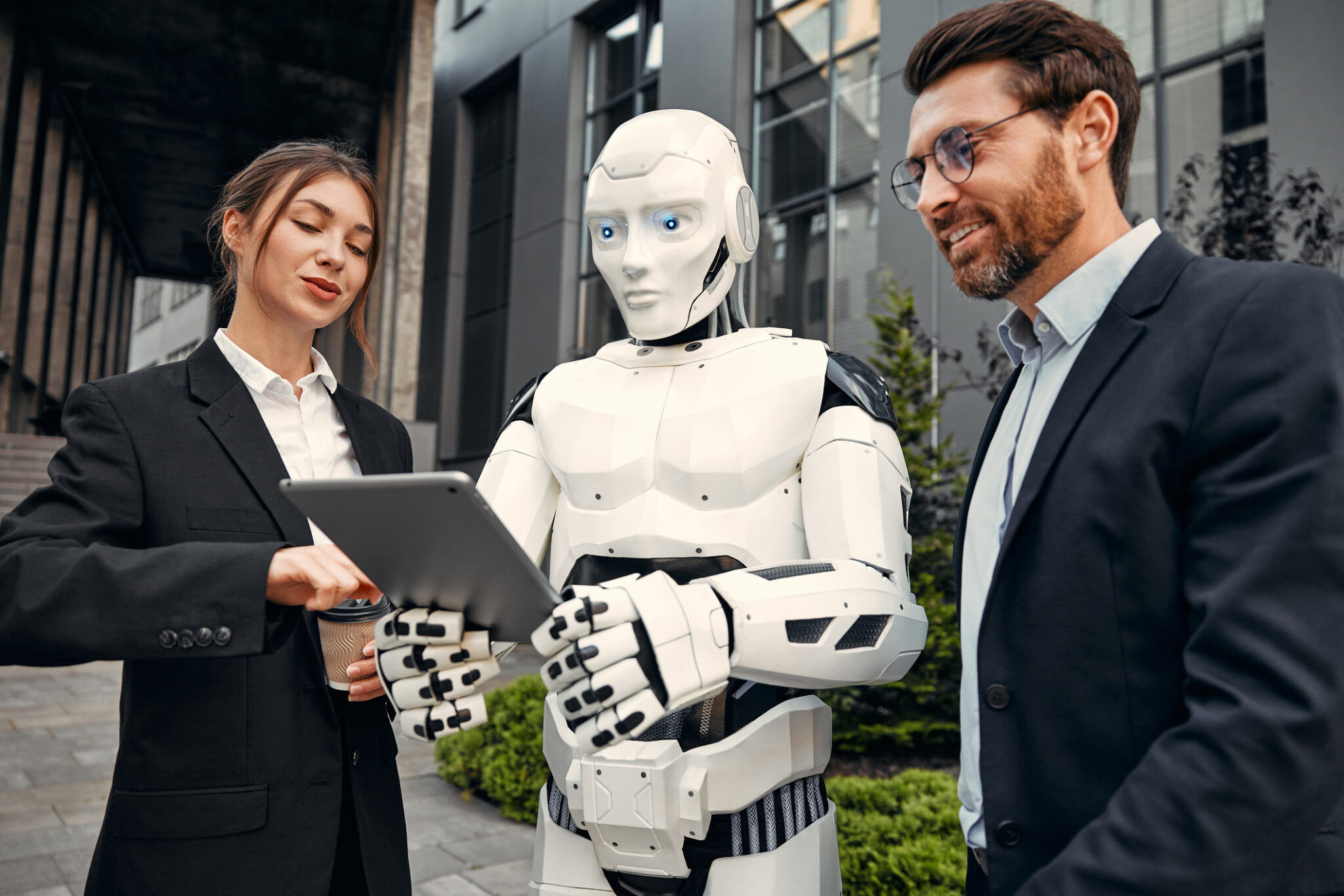 Robot with businessmen on the street near the building